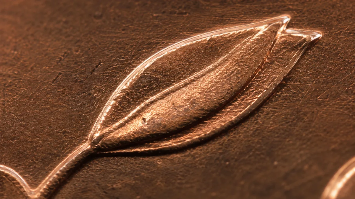 Extreme macro of a raised letter with a second overlapping impression at equal height and notched corners