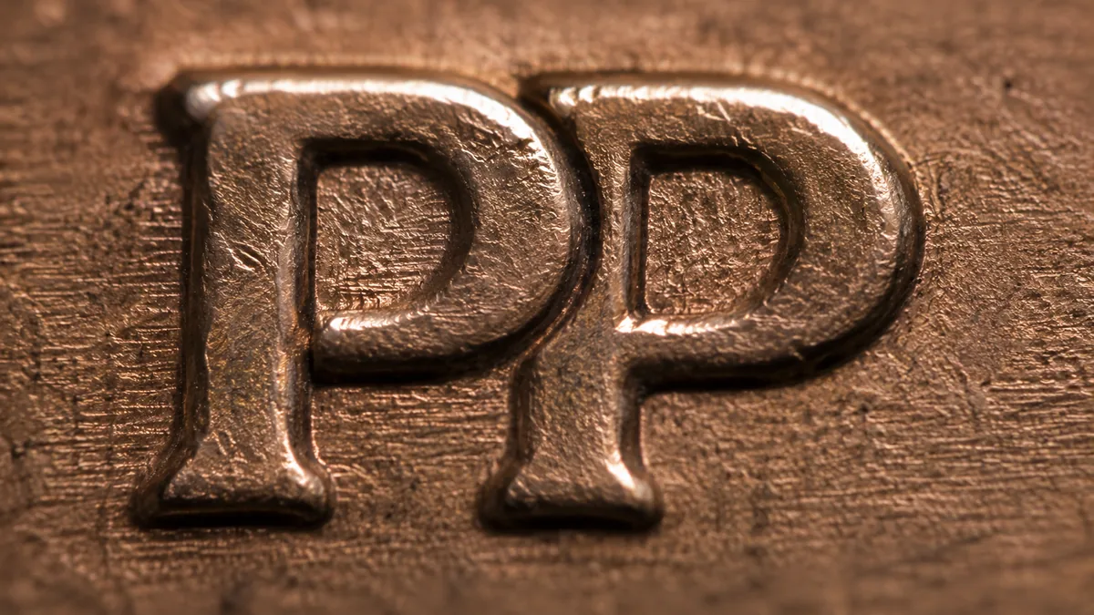 A coin with a thick smooth rolled rim and reduced diameter beside a normal cent