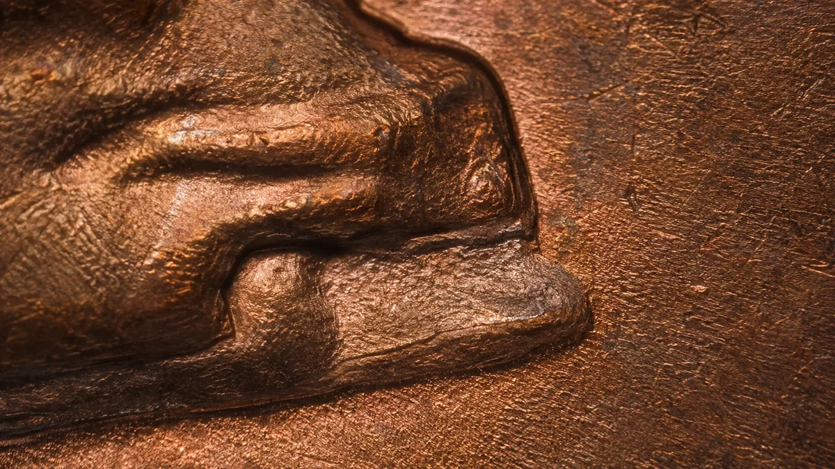 Extreme macro of a raised device with a low flat shelf of smeared metal stepping down beside it