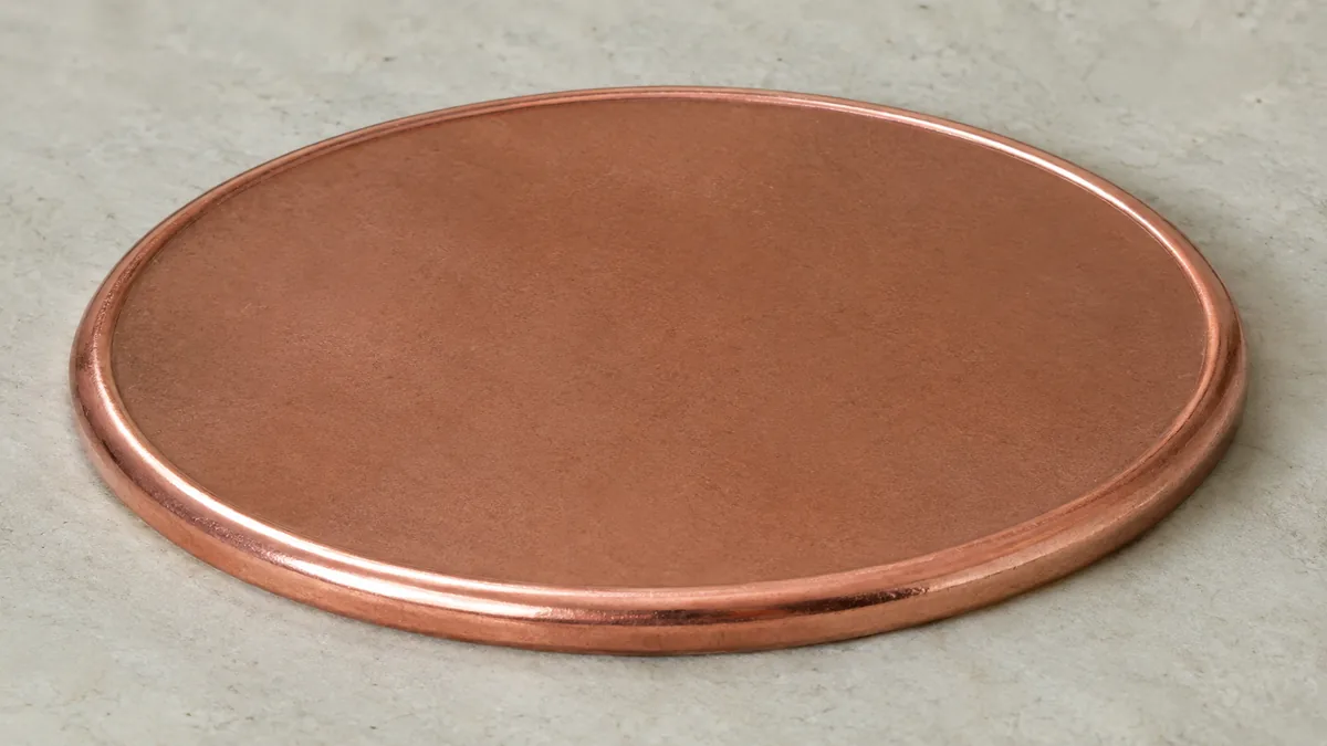 A thin weakly struck coin beside a piece showing a rough granular interior surface