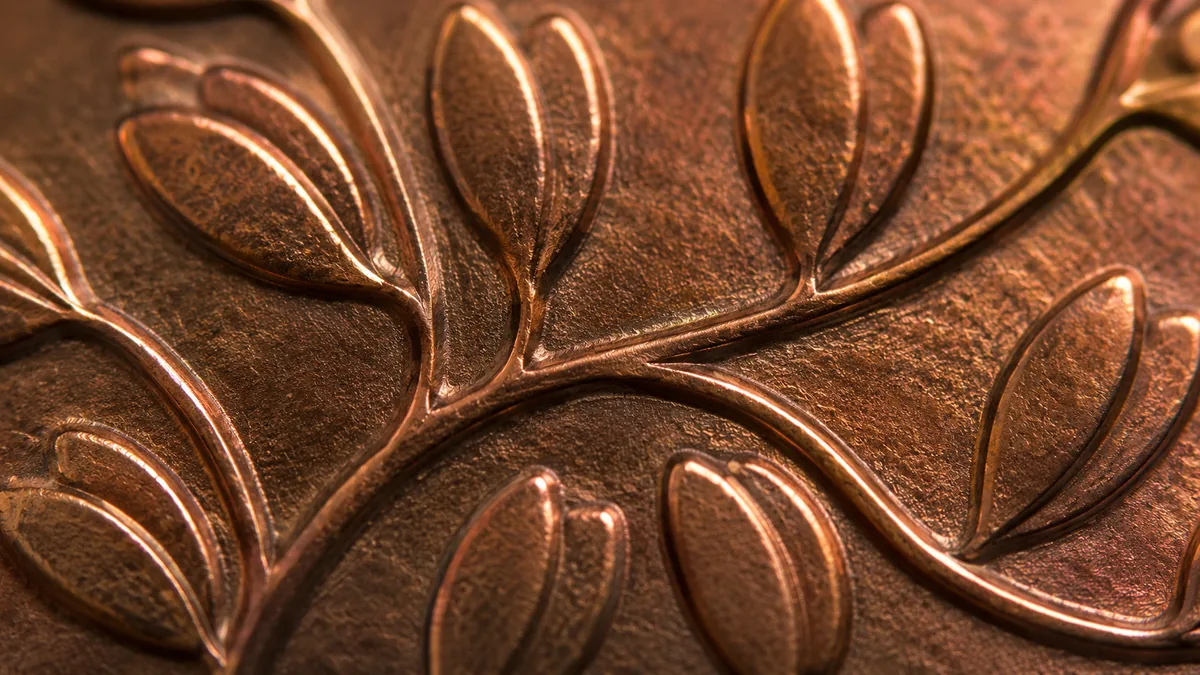 A coin with an uneven hammered rim covered in overlapping tool facets and a dished face